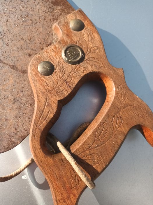 Serrote manual  cabo  madeira entalhada, tacha metálica  marca  Bolota