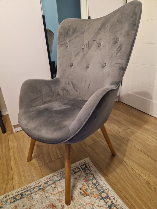 Fotel szary z nogami w koleorze naturalnego drewna