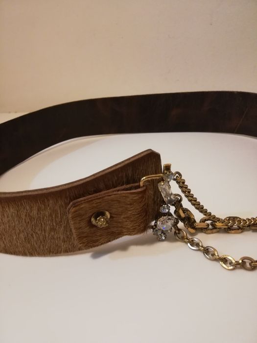 Cinto em pêlo camel, com aplicações douradas com brilhantes.