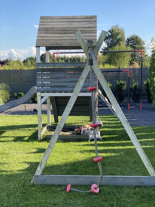 Plac zabaw drewniany z wieżą, huśtawkami, ścianką wspinaczkową i liną