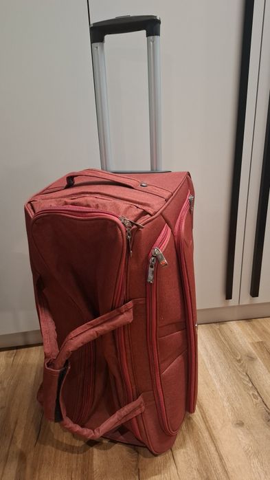 Дорожня вмістка сумка на колесах червоного кольору. Нова.