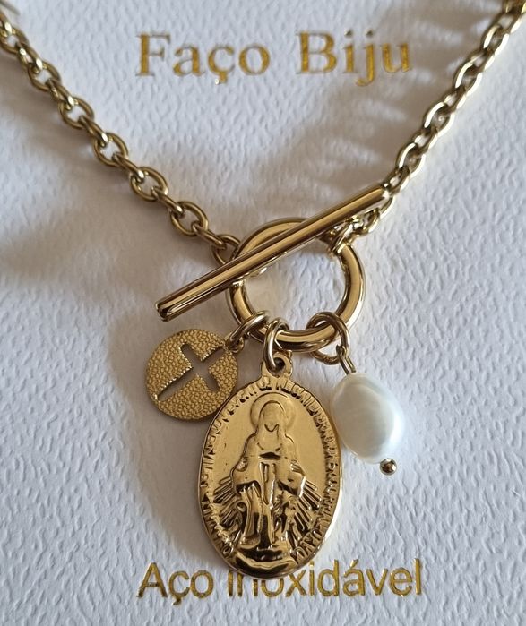 Colar dourado, em aço, com 3 pingentes diferentes. Fecho em T à frente