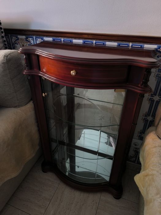 Vitrine em madeira com frente curva, gaveta e prateleiras em vidro