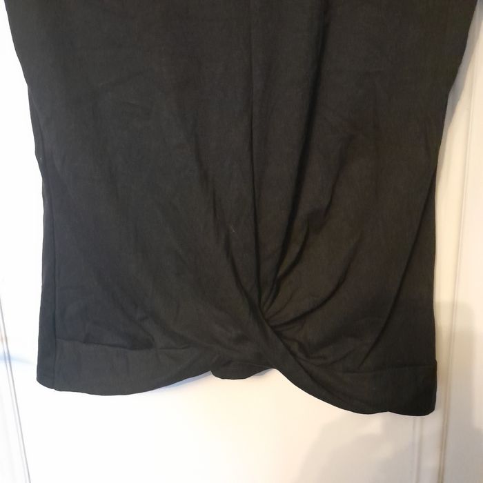 Blusa preta mangas curtas, traçada à frente na zona do cós, decote V