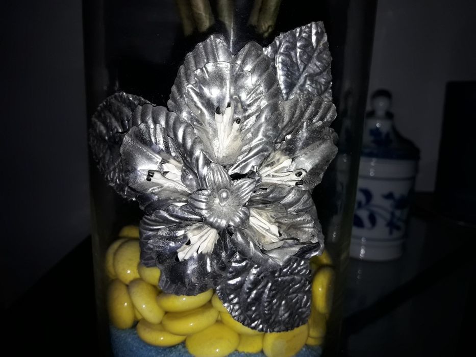 Jarra de vidro com flor em estanho