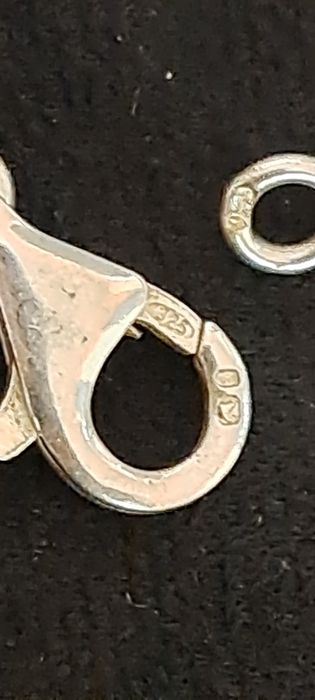 Cordão corrente com pendente em prata contrastada.