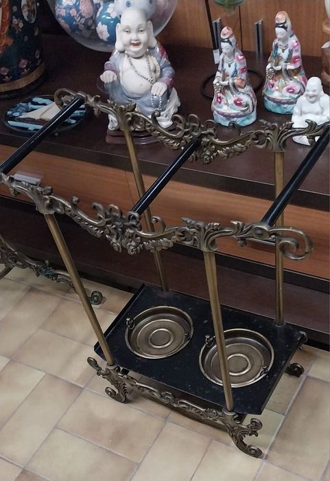 Base para guarda chuvas e espelho de parede com bengaleiro e chapeleiro. Em latão.Mesa meia lua.