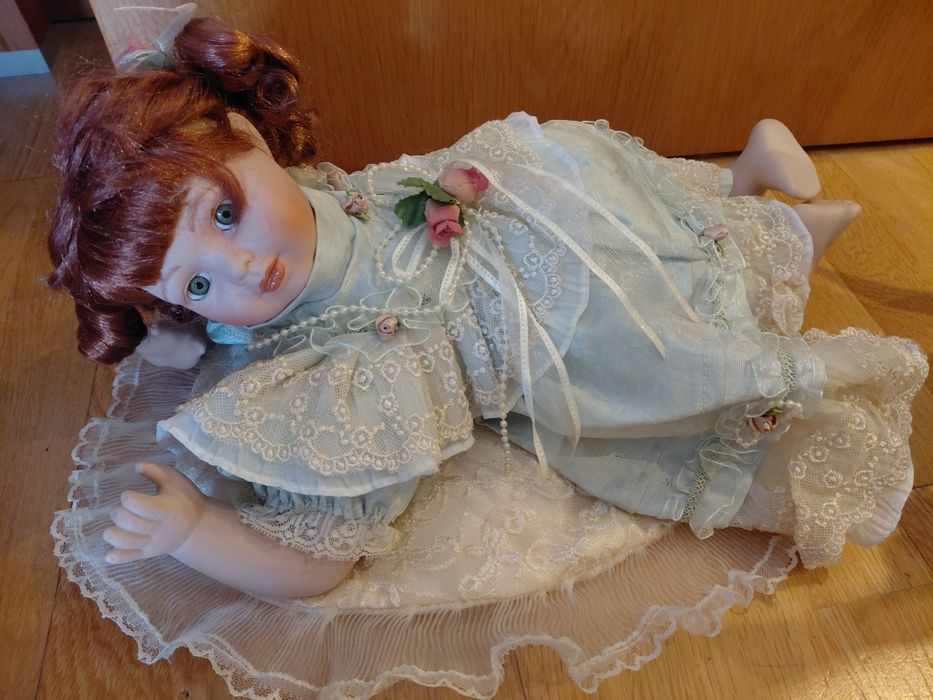 Boneca de porcelana com almofada