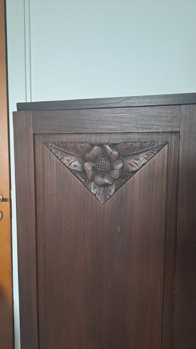 Armário antigo com entalhes florais e prateleiras