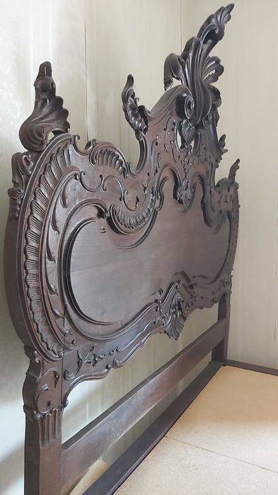 Cama casal com cabecera e estructura de madeira maciça e esculpida.
