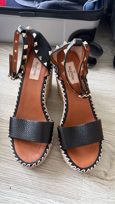 Sandália Valentino Gravani destacam-se pelo elegante desing em couro preto granulado com tachas douradas icônicas