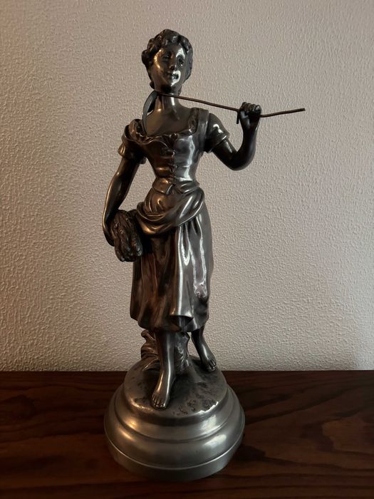 Estatueta feminina metálica