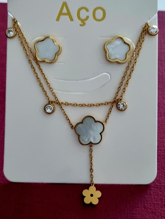 Conjunto dourado (colar duplo e brincos), em aço, com flores brancas em madrepérola.