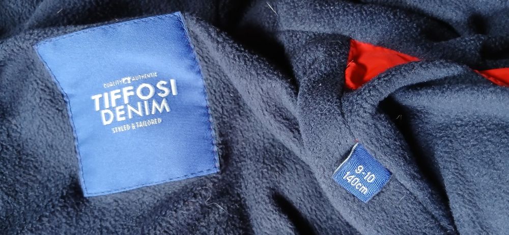 Blusão vermelho Tiffosi. blusão azul e calças de ganga, de crinça.