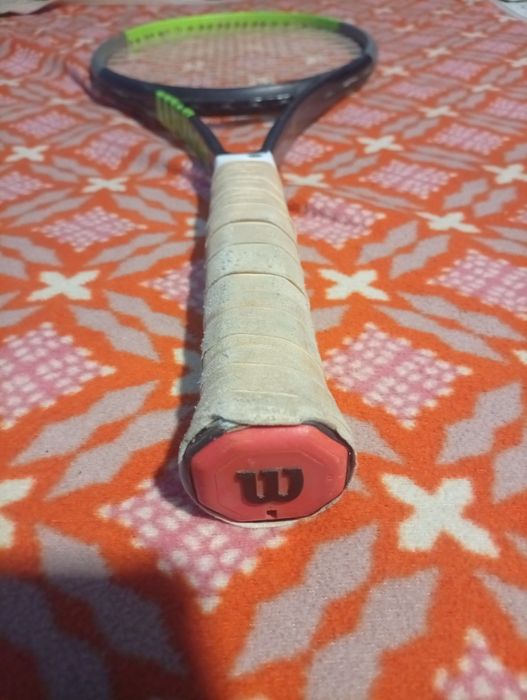 raquete de ténis é uma Wilson Blade V7, reconhecível pelo seu design