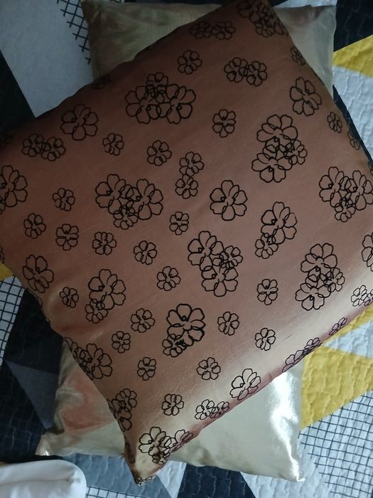 Almofadas em dourado e outra estampada