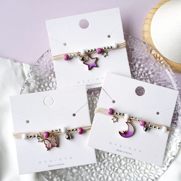 Pulseira/tornozeleira estrelas em tons de lilás, azul e rosa.