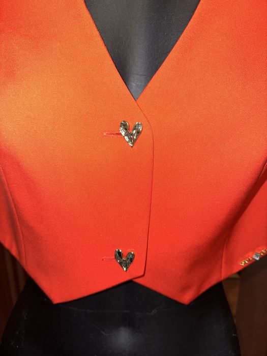 Colete vermelho Sahoco com botões dourados em forma coração