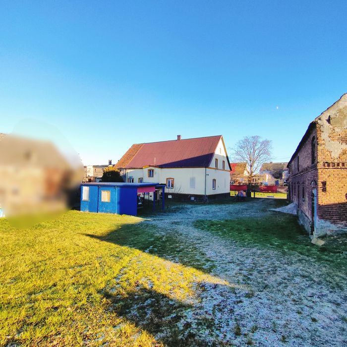 Dom na wsi z dużym budynkiem gospodarczym