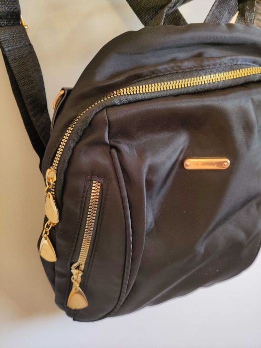 Mochila preta com detalhes dourados