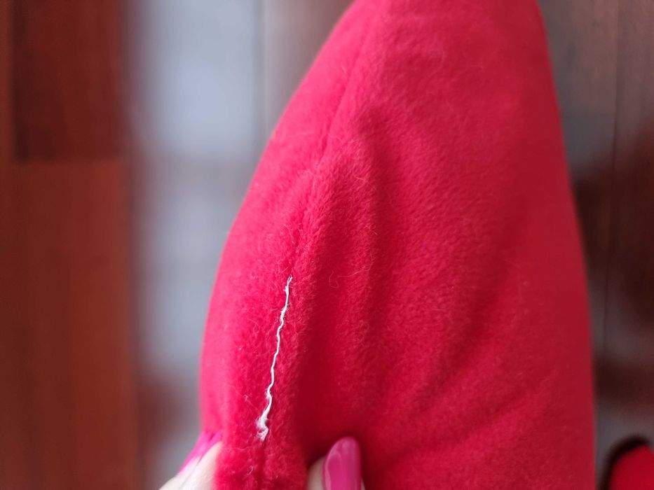Almofada vermelha em formato de coração com os braços abertos