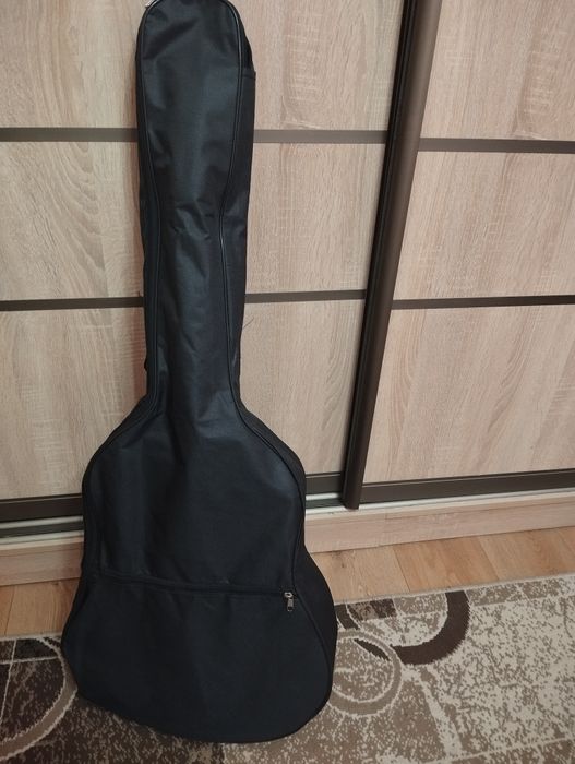 Акустична гітара чорного кольору. В комплекті 4 медіатори, каподастр