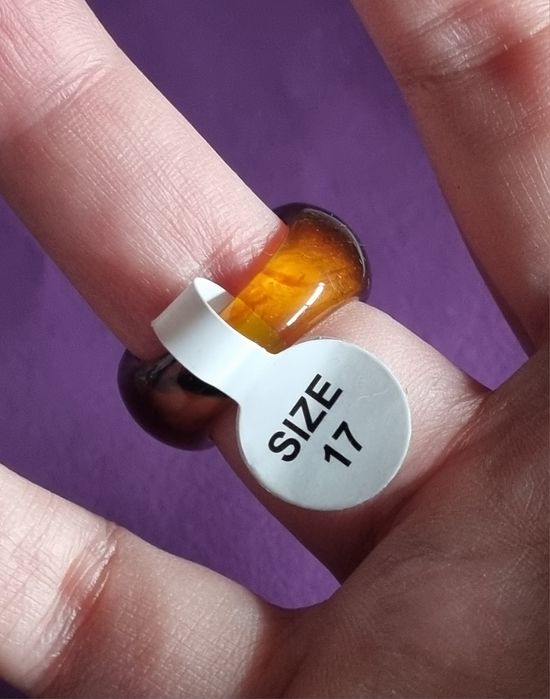 Anel em acrílico castanho com sol dourado, em aço. T17