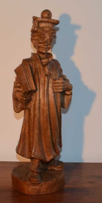 Estatueta esculpida em madeira maciça, representando um estudante universitário