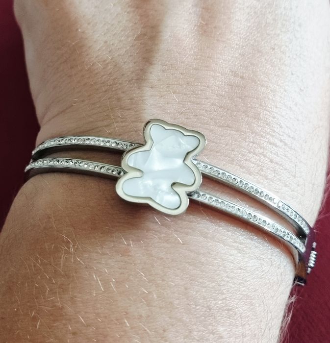 Pulseira/escrava prateada, em aço, com zirconias e um urso em madrepér