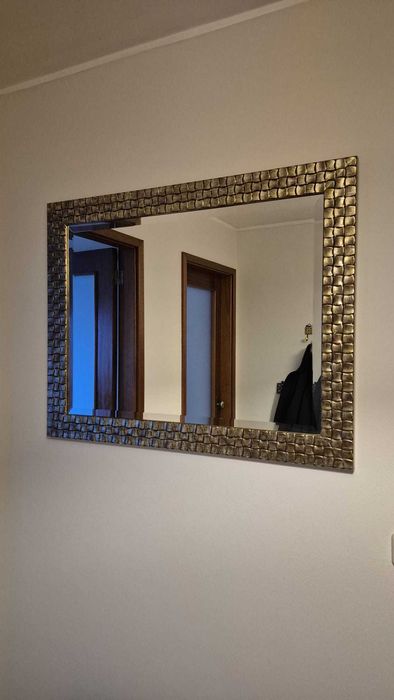 Vendo espelho com moldura dourada com relevos