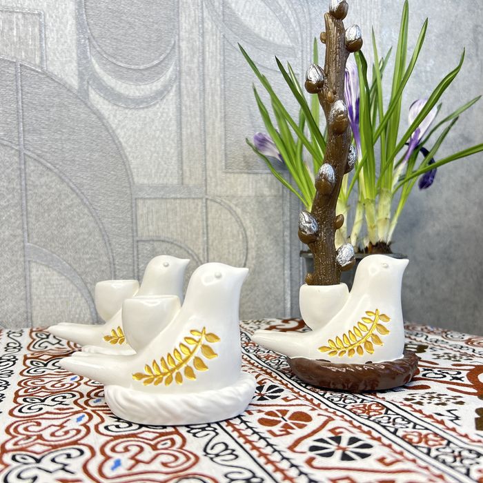 Гіпсова  пташка та свічка верба на великдень.