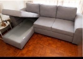 Sofá chaise longue em tecido cinzento, usado mas em bom estado geral.