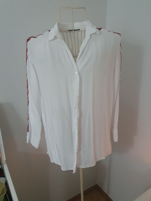 Camisa branca com linhas vermelhas nos braços