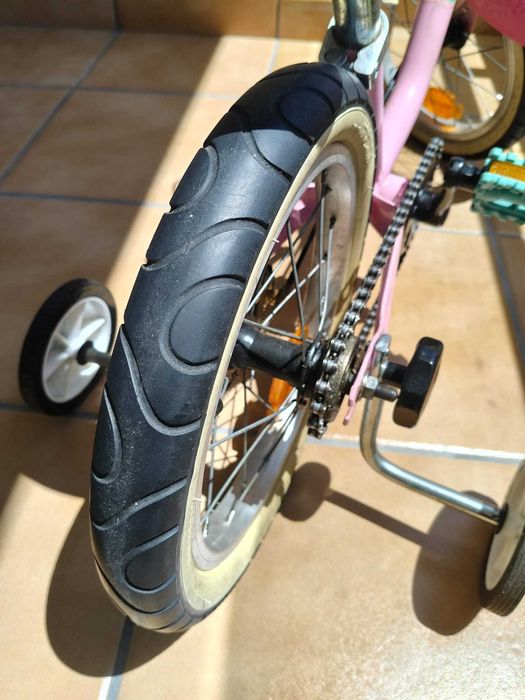 Bicicleta infantil rosa com rodinhas de apoio