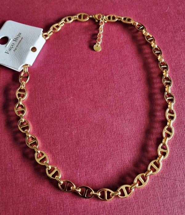 Colar/gargantilha dourada, em aço inoxidável. Tem extensor