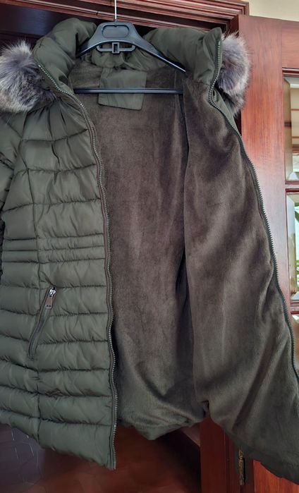 Casaco de impermeável de mulher com carapuço forrado a pelo.