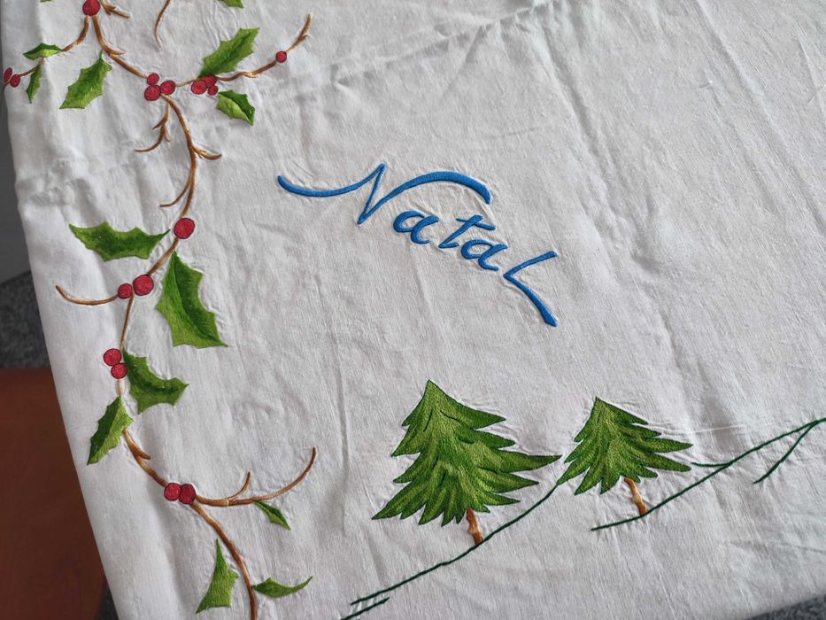Toalha de natal branca com bordados natalícios.