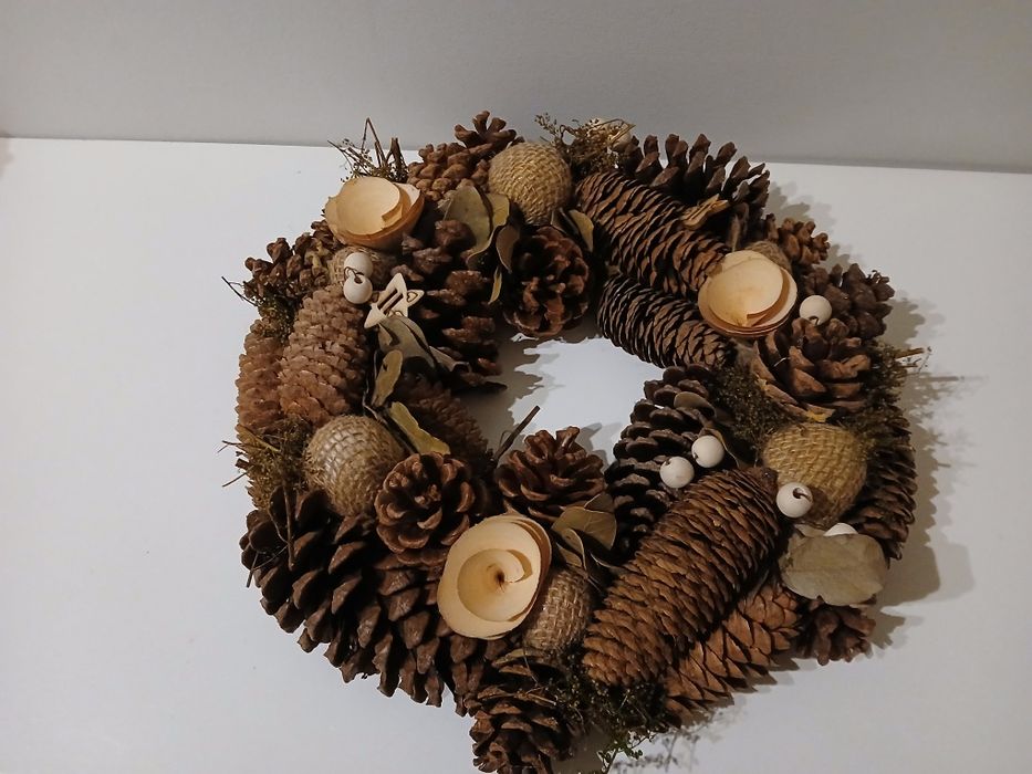 Coroa com pinhas e decorações de madeira