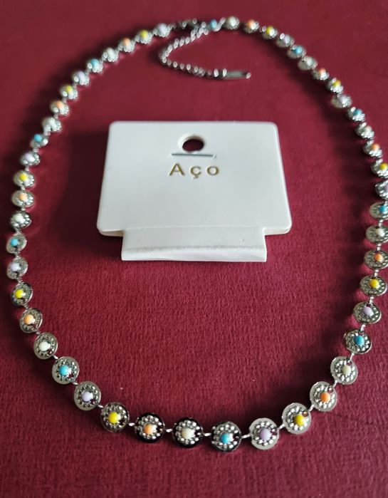 Colar/gargantilha prateado, em aço, com pequenas bolinhas coloridas. T