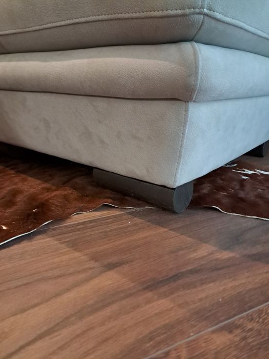 Pufe creme aveludado com pés em madeira