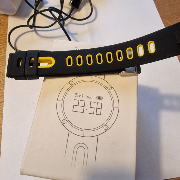 Smartwatch z paskiem i kablem do ładowania