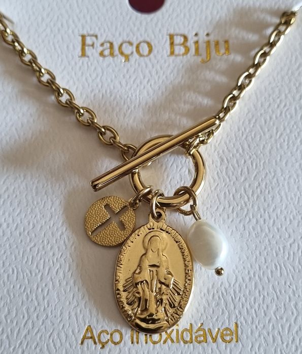 Colar dourado, em aço, com 3 pingentes diferentes. Fecho em T à frente