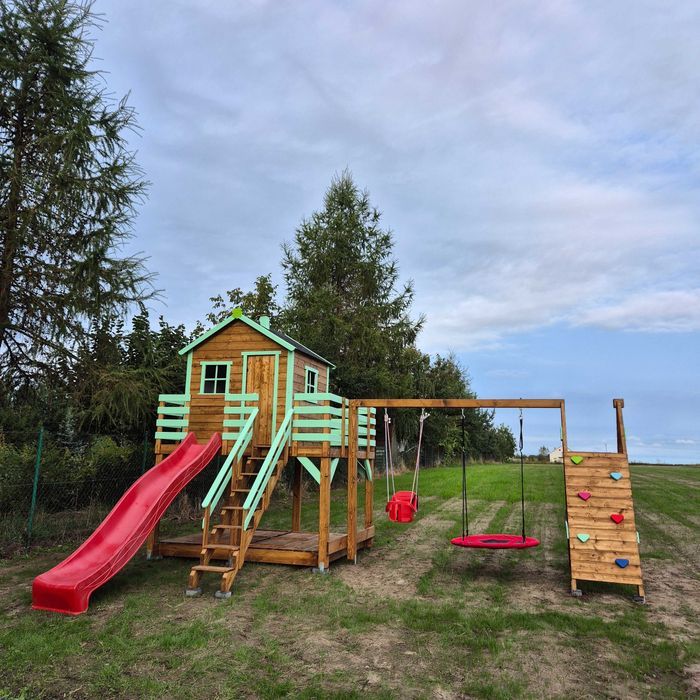 Plac zabaw Domek na powiększonym podeście z huśtawkami i ścianką wsp.