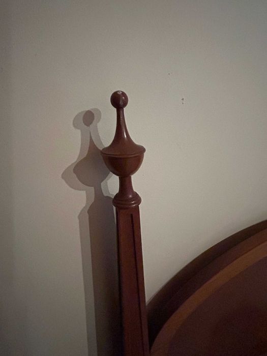 Cama antiga de colunas com cabeceira oval