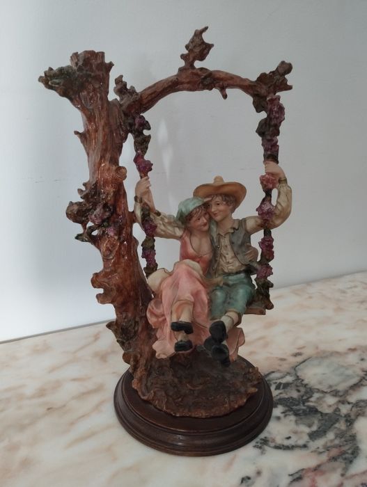 Vintage decorative piece: couple on a swing with wooden base