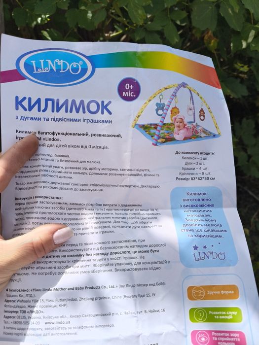 дитячий розвиваючий килимок з дугами та підвісними іграшками.