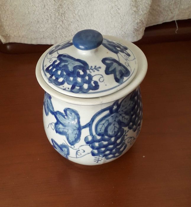 Pote branco e azul, com tampa, com desenhos de uvas