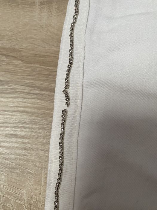 Białe spodnie z paskami z diamencików