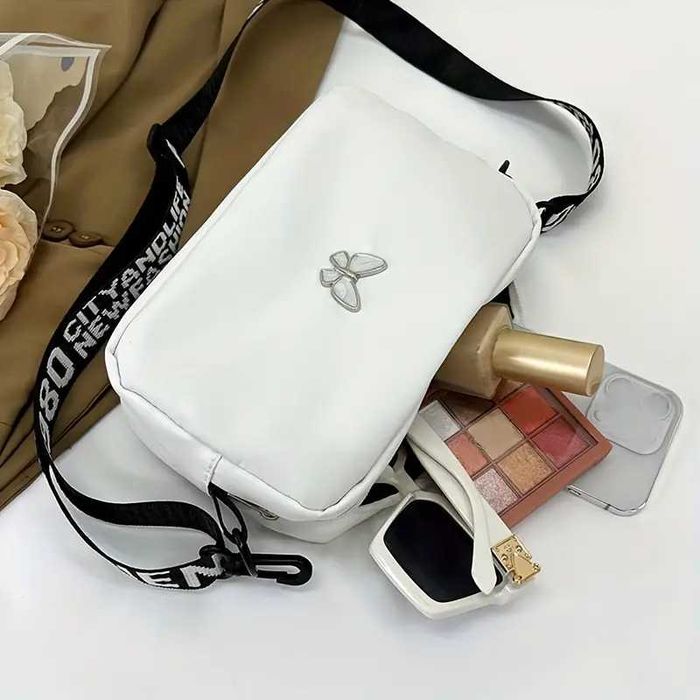 Чорна сумочка, біла сумочка та червона з метеликом