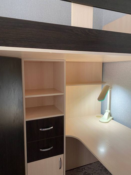 Ліжко двоповерхове разом із столом, поличками та шафою.